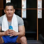 Pria dengan handuk di gym usai latihan, gambaran artikel tentang fat burner terbaik untuk mendukung pembakar lemak dan performa olahraga